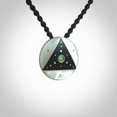 This photo shows a triangle disc pendant hand carved from ebony with nz paua shell, Mother of Pearl alongside; brass and silver. This is a stand out one off necklace for those who appreciate art to wear. It is provided with a cord in black that is a fixed length with Paua Shell Toggle. We ship this piece worldwide and shipping is included in the price.
